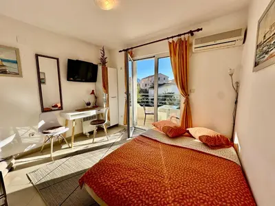 a bedroom with a bed and a view of a balcony at Budva - Becici in Becici