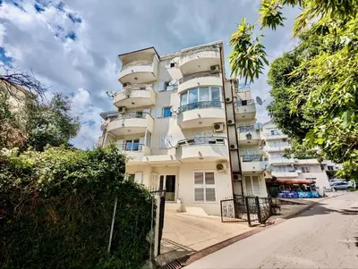 a tall white building with balconies on a street at Budva - Becici in Becici