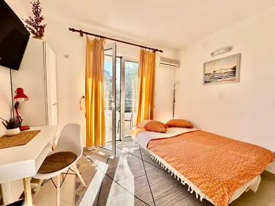 a bedroom with a bed and a desk and a window at Budva - Becici in Becici