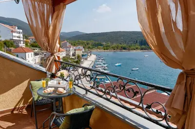 a balcony with a table and a view of the water at Beachfront Villa Adria - Happy Rentals in Kotor