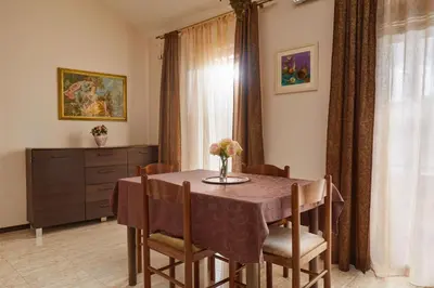 a dining room with a table with chairs and a dresser at Beachfront Villa Adria - Happy Rentals in Kotor