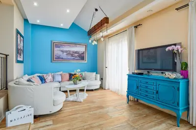 a blue living room with a couch and a tv at Beachfront Villa Adria - Happy Rentals in Kotor
