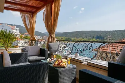 a balcony with chairs and a table with fruit on it at Beachfront Villa Adria - Happy Rentals in Kotor