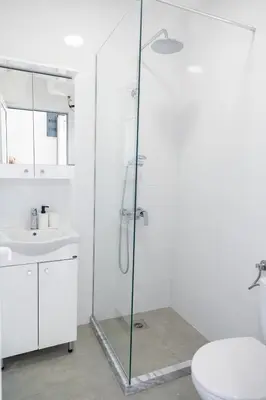 a bathroom with a shower and a toilet and a sink at Apartments Chiara Garden in Ulcinj