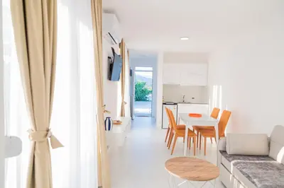 a living room and kitchen with a couch and a table at Apartments Chiara Garden in Ulcinj
