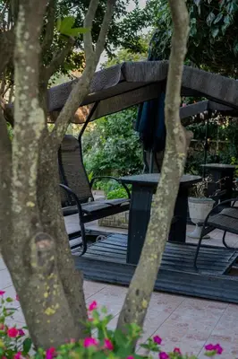 a wooden bench sitting on a patio next to trees at Apartments Chiara Garden in Ulcinj