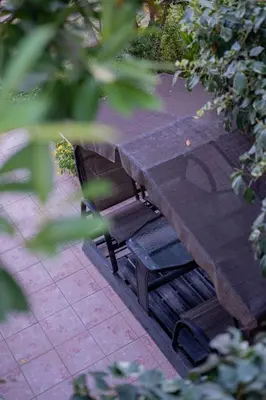 a wooden bench sitting under a picnic table at Apartments Chiara Garden in Ulcinj
