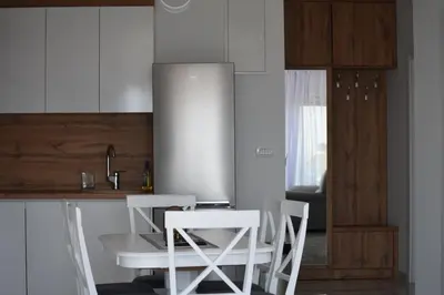 a kitchen with a white table and two white chairs at Buskovic Bella Vista in Dobra Voda