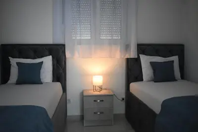 a bedroom with two beds with a lamp on a night stand at Buskovic Bella Vista in Dobra Voda