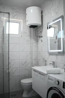a bathroom with a toilet and a sink and a mirror at Buskovic Bella Vista in Dobra Voda