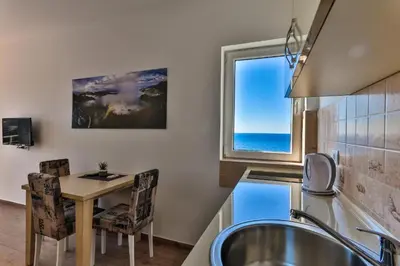 a kitchen with a table and a sink and a window at Buskovic Bella Vista in Dobra Voda