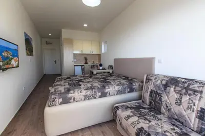 a bedroom with a large bed and a couch at Buskovic Bella Vista in Dobra Voda