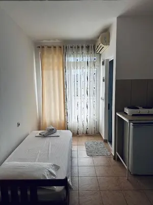 a room with a bed and a kitchen with a window at Apartments Duraku in Ulcinj