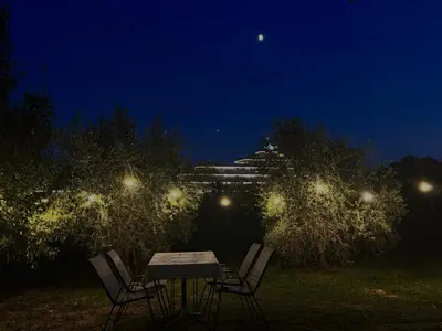 a table and chairs in a yard at night at Apartments Duraku in Ulcinj