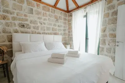 a bedroom with a white bed with towels on it at Casa di Pietra in Kotor