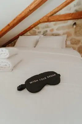 a bed with a black pillow that reads when love arrives at Casa di Pietra in Kotor