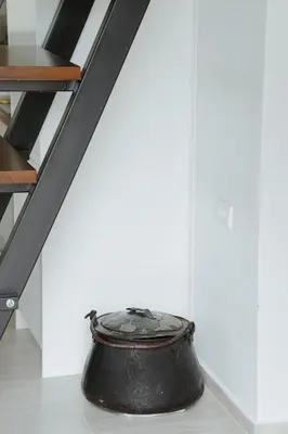 a large black pot sitting on the floor under a staircase at Casa di Pietra in Kotor
