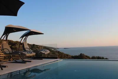 a swimming pool with chairs and a view of the ocean at Luxury Villa Lorcrimar in Masline