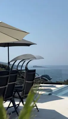 a group of chairs and umbrellas on a patio at Luxury Villa Lorcrimar in Masline