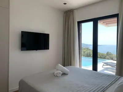 a bedroom with a bed with a television and a balcony at Luxury Villa Lorcrimar in Masline