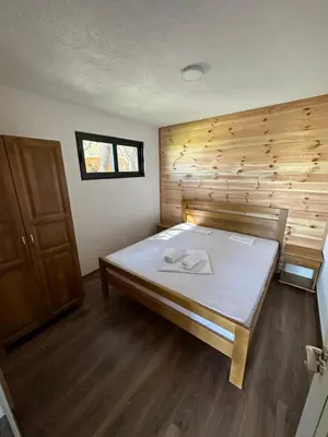 a large bed in a room with a wooden wall at Imperial Family Bungalows in Ulcinj