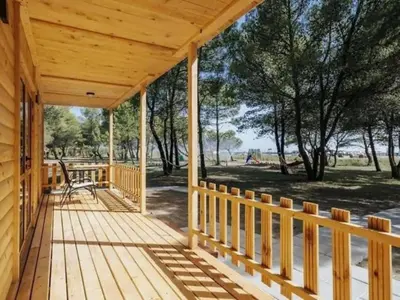 a porch of a wooden house with a view of a park at Imperial Family Bungalows in Ulcinj