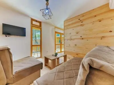 a bedroom with a bed and a flat screen tv at Imperial Family Bungalows in Ulcinj