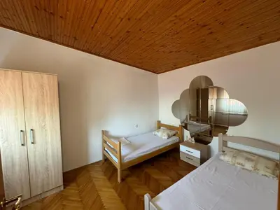 a bedroom with a bed and a wooden ceiling at Vlado apartments in Podgorica