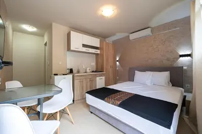 a bedroom with a bed and a table and a kitchen at Villa Glamour in Utjeha