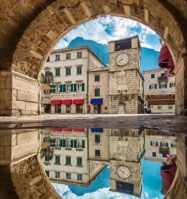 a reflection of a clock tower in the water under a bridge at B&L Chic apartment in Škaljari