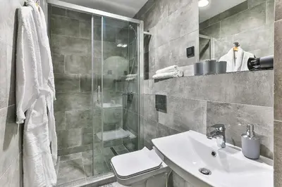 a bathroom with a toilet and a sink and a shower at Apartments Magic box II in Utjeha