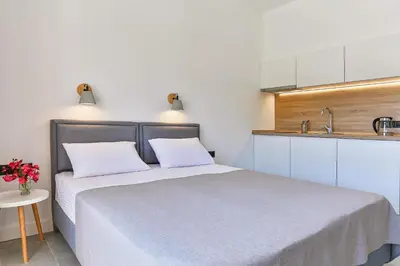 a small bedroom with a bed and a sink at Apartments Magic box II in Utjeha