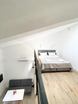 a bedroom with a bed and a table in it at Apartments Magic box II in Utjeha