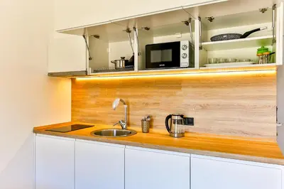a kitchen with a sink and a microwave at Apartments Magic box II in Utjeha