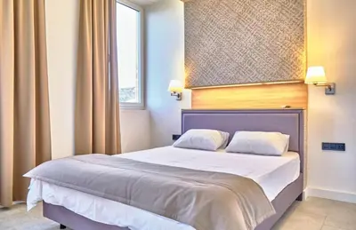 a bedroom with a large bed with white sheets at Apartments Magic box II in Utjeha