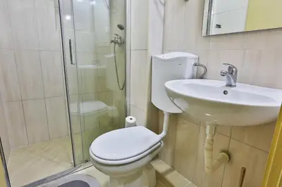 a bathroom with a toilet and a sink and a shower at Basilica Apartments in Budva