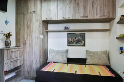 a bed in a room with wooden cabinets at Basilica Apartments in Budva