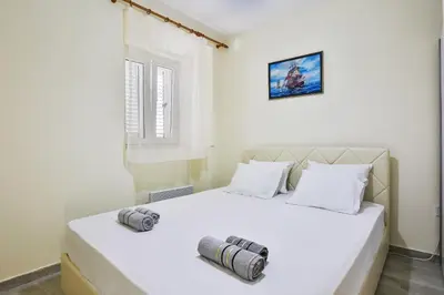 a bedroom with a white bed with two pillows at Basilica Apartments in Budva