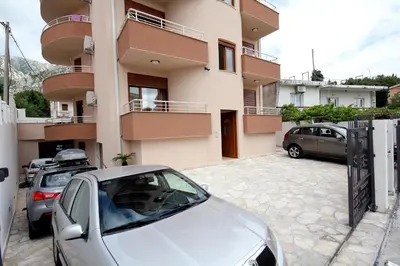 a white car parked in front of a building at Apartments Md Lux in Sutomore