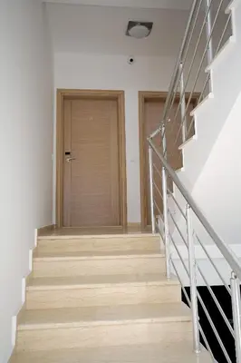 a staircase with a wooden door in a house at Apartments Md Lux in Sutomore