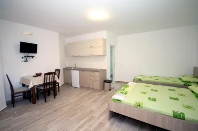 a bedroom with two beds and a table and a desk at Apartments Md Lux in Sutomore