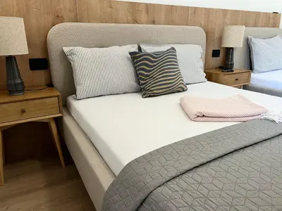 a bedroom with a bed with two night stands and two lamps at Apartments Mrdak in Bar