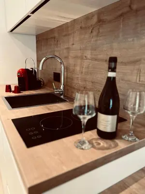 a bottle of wine sitting on a counter with two wine glasses at Apartments Mrdak in Bar