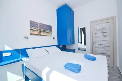 a blue and white bedroom with a large bed at Apartments A Čanj in Čanj