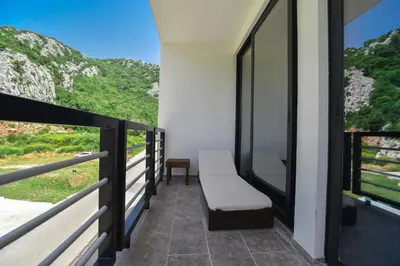 a balcony with a bench and a view of a mountain at Apartments A Čanj in Čanj