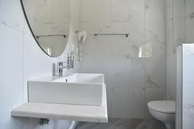 a white bathroom with a sink and a mirror at Apartments A Čanj in Čanj