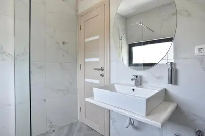 a white bathroom with a sink and a mirror at Apartments A Čanj in Čanj
