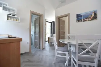 a kitchen and dining room with a table and chairs at Apartments A Čanj in Čanj