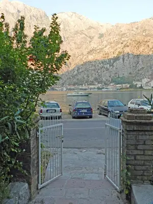 a gate to a parking lot with parked cars at Apartment Mimosa in Kotor