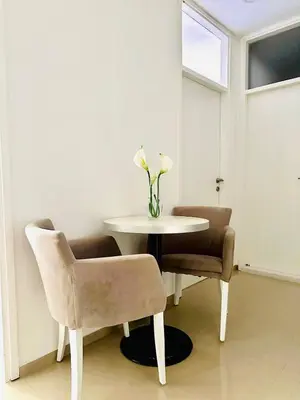 a table with two chairs and a vase with flowers on it at Nora Apartment in Budva